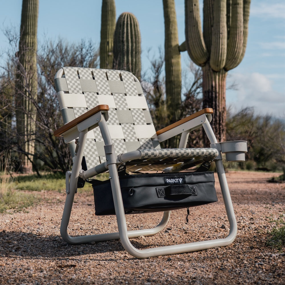 a single camp chair next to saguaro trees 